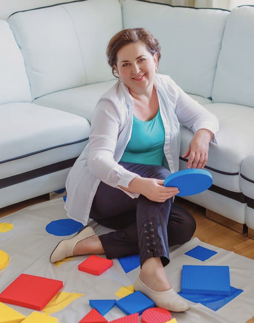 Tania Plaskon sitting with Montessori learning materials